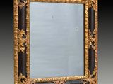 un miroir richement décoré, doté d'un cadre noir et or