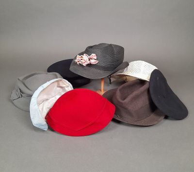 Plusieurs chapeaux sont alignés sur une surface grise