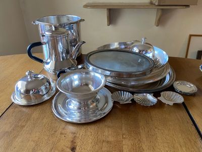 a wooden table with a lot of silver items on it