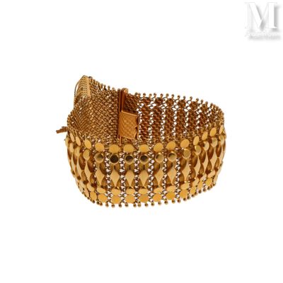 une image d'un gros plan d'un bracelet en or sur un fond blanc