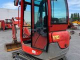 an image of a red and black tractor parked in a lot