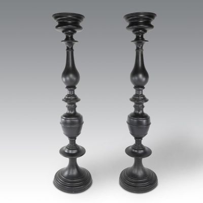 une paire de bougeoirs noirs sur fond gris