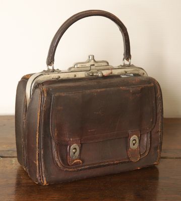 un petit sac marron posé sur une table en bois