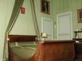 un lit surmonté d'un baldaquin, dans une chambre