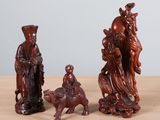trois figurines en bois représentant des personnes et des animaux, posées sur une table
