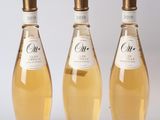 trois bouteilles de vin posées les unes à côté des autres sur une surface blanche
