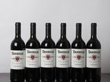 six bouteilles de vin rouge sont alignées sur une table en bois