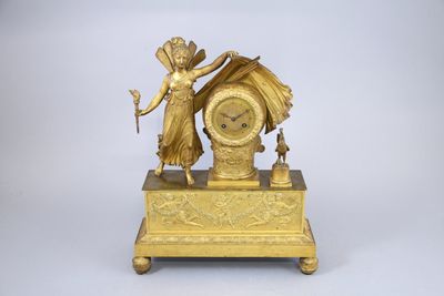 une horloge en or surmontée d'une statue