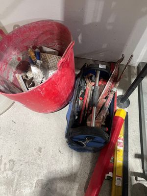 un seau rempli d'outils posé par terre à côté d'une porte