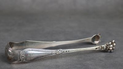 une cuillère en argent ornée d'une fleur, posée sur une table