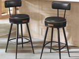 deux tabourets noirs placés dans une cuisine, à côté d'un plan de travail