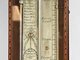 a clock that has a barometer on the side of it