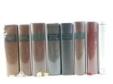 several books are lined up in a row on a white surface