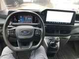 a man sitting in the driver ' s seat of a car