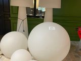 a lot of white balls on the floor next to a lamp