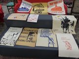 many t - shirts on display on a blue couch