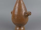 a small brown vase with a bird on top of it