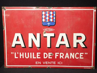 une vieille enseigne rouge et blanche sur laquelle figure un blason
