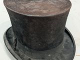 a black top hat sitting on top of a white table