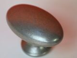a shiny metal knob on a white surface