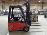 a red forklift truck in a warehouse with other equipment