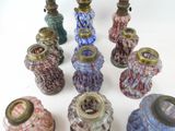 many different colored glass vases on a white surface