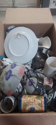 une boîte remplie de tasses à thé, de soucoupes et d'une assiette
