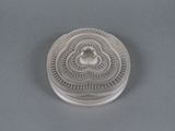 an antique silver plate with a bird on it on a gray surface