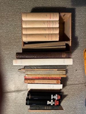 une pile de livres posée par terre à côté d'une batte de baseball