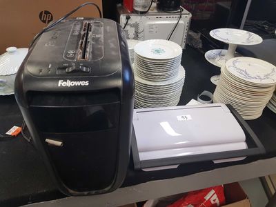 a black toaster sitting on top of a table next to a stack of plates