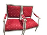 a pair of red upholstered chairs with gold dots on them