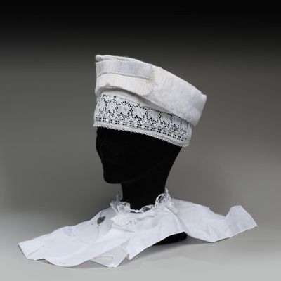 chapeau blanc orné de dentelle et d'un ruban, posé sur la tête d'un mannequin