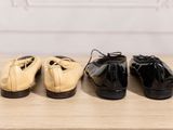 three pairs of shoes are lined up on a wooden table