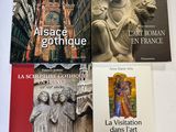 quatre livres posés sur une table recouverte d'une nappe blanche