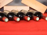 several bottles of wine are lined up on a red table