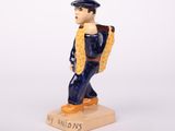 figurine of a man with a backpack on a base