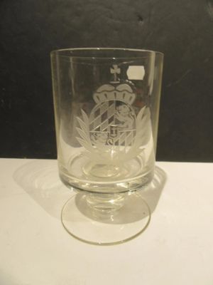 a glass with a design on it sitting on a table