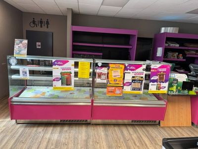 a display case in the middle of a store filled with food