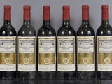 six bottles of wine are lined up in a row on a table