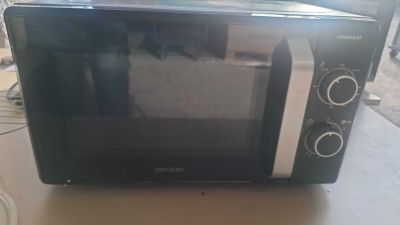 un micro-ondes noir et argent posé sur une table