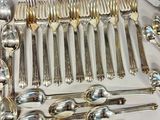a lot of silver spoons and forks on the table