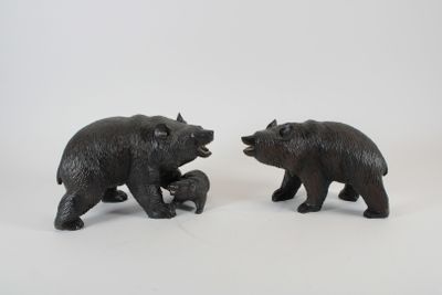 deux ours noirs debout l'un à côté de l'autre sur une surface blanche