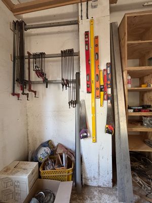 une photo d'une pièce avec une échelle et des outils accrochés au mur