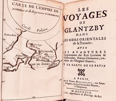 an old book with a map on it sitting on a table