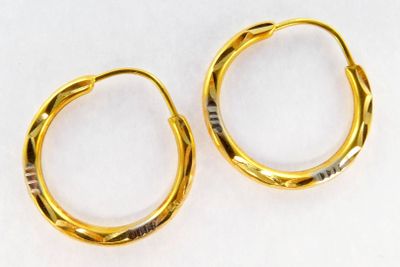 two pairs of gold hoop earrings on a white surface