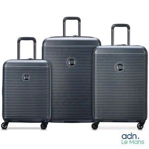 trois bagages posés les uns à côté des autres sur une surface blanche
