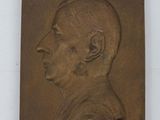 un gros plan sur une plaque en bronze représentant le visage d'un homme