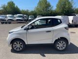 a small white car that is parked in a parking lot