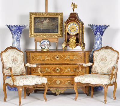 deux chaises et une commode sur laquelle se trouve une horloge
