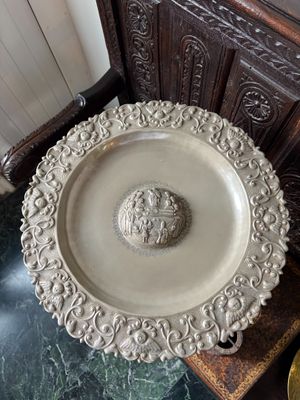 une assiette blanche ornée d'une tête de lion, posée sur une table en marbre